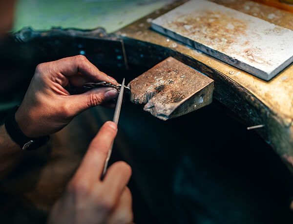 Person filing a piece of jewelry